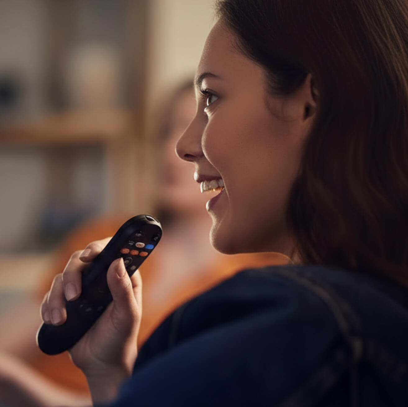 A woman holding a voice remote